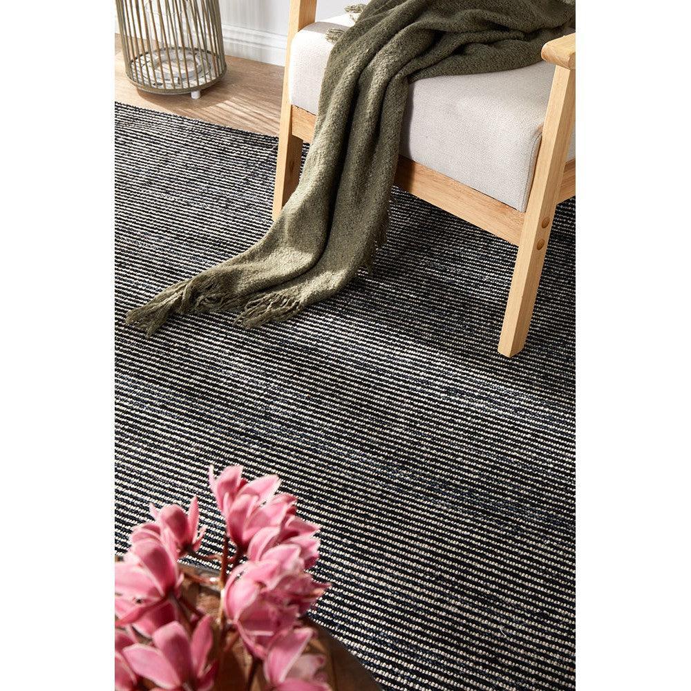 Allie Black Cotton Rayon Rug featuring striped pattern in charcoal, white and grey on neutral floor, machine-made blend