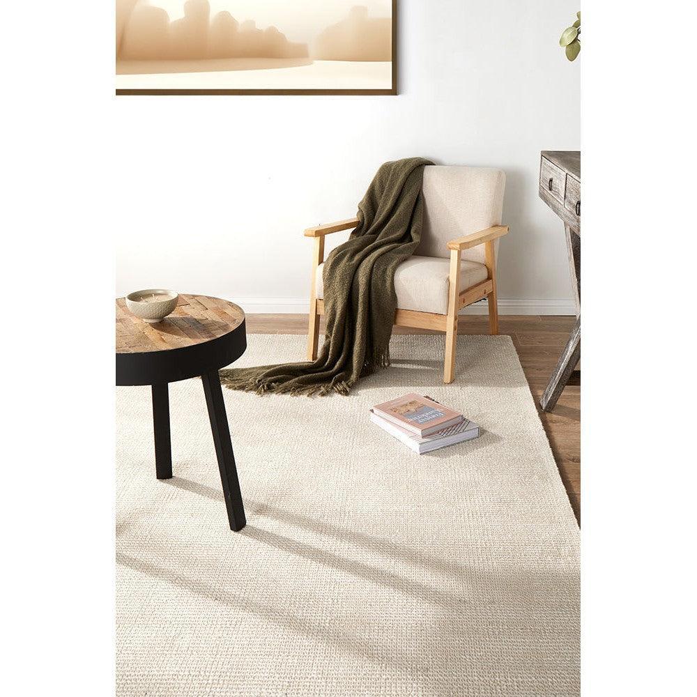 Allie Ivory Cotton Rayon Rug featuring solid ivory in a soft textured weave on light beige floor with a neutral living room setting