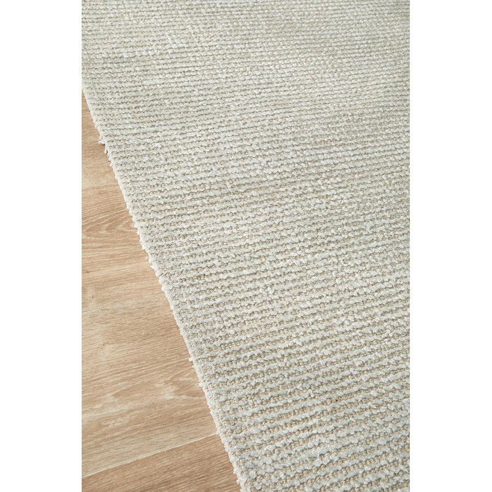 Allie Sky Cotton Rayon Rug featuring textured solid weave in ivory, cream and light beige on natural wood floor, machine-made cotton-rayon