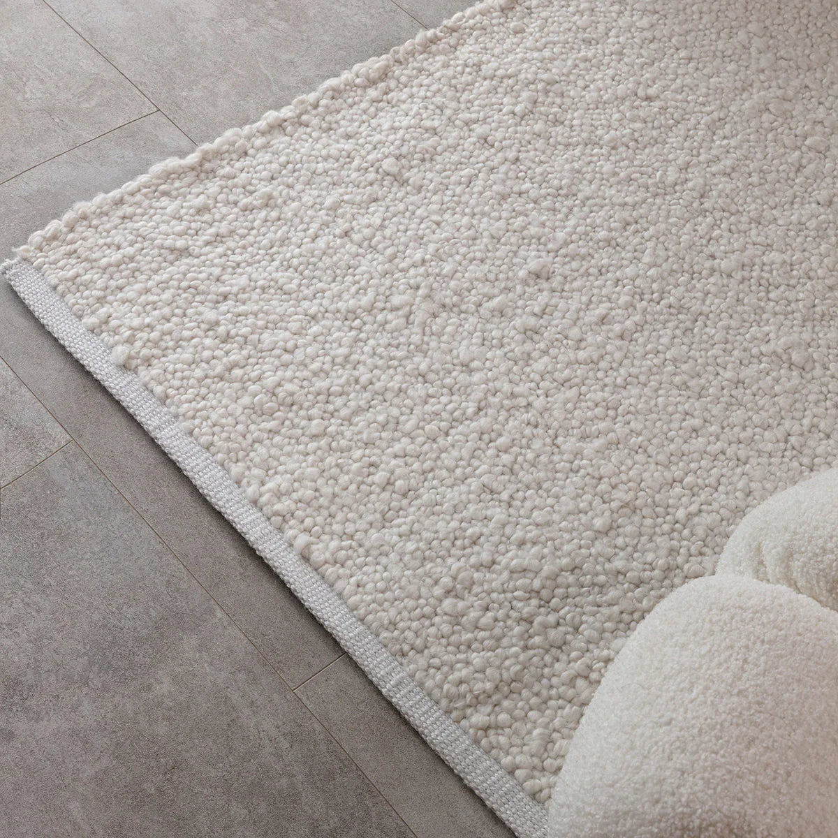 Asiatic Abbus Ivory Designer Rug featuring shag texture in ivory, cream and beige on light grey tile, hand-tufted wool