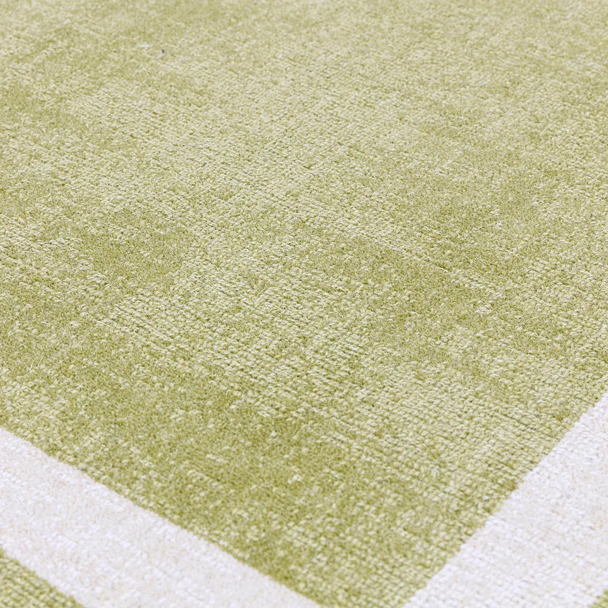 Asiatic Albi Green Rug featuring tonal olive-green texture with cream border on light beige background, hand-tufted wool