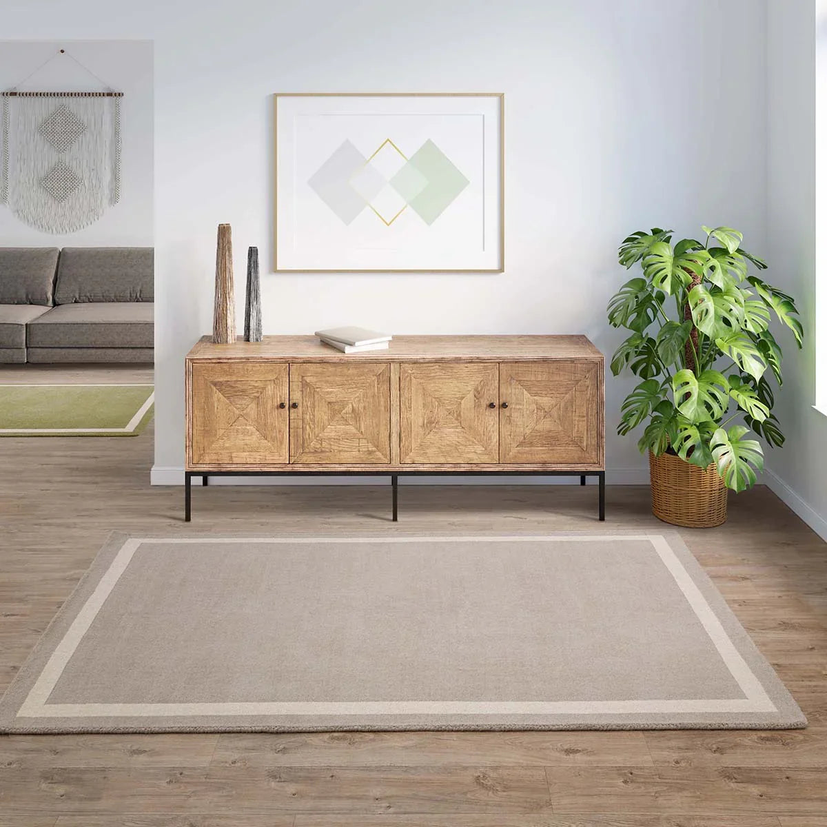 Asiatic Albi Sand Designer Rug featuring solid with border in sand beige and cream on warm wood floor, power-loomed wool