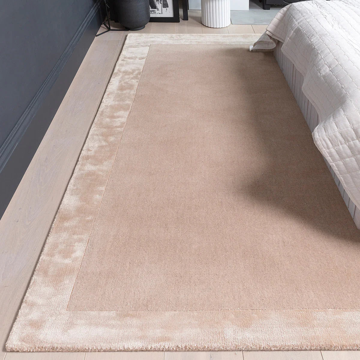 Asiatic Ascot Putty Rug featuring solid field with cream border in putty and beige on light brown floor, tufted wool