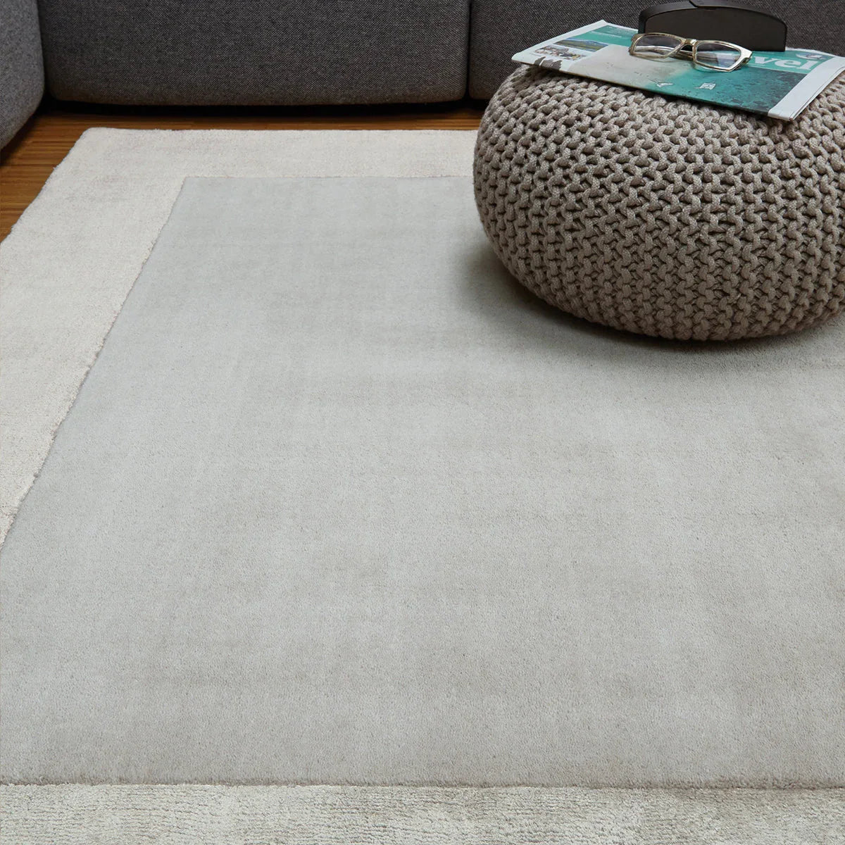 Asiatic Ascot Silver Designer Rug featuring border in silver-grey centre and cream edge on brown floor, machine-made wool