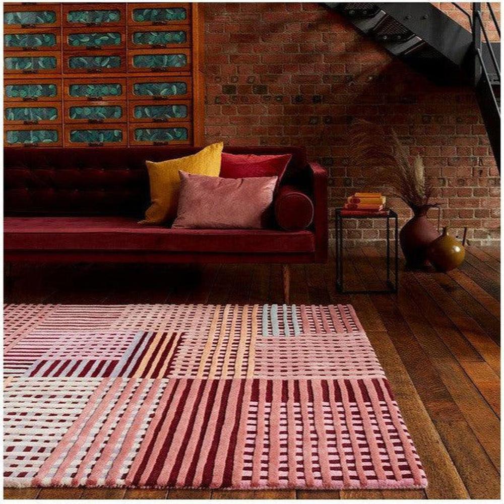 Asiatic Aspect Red Designer Rug featuring geometric patchwork in pink, rose, maroon and cream on natural wooden floor, machine-loomed wool