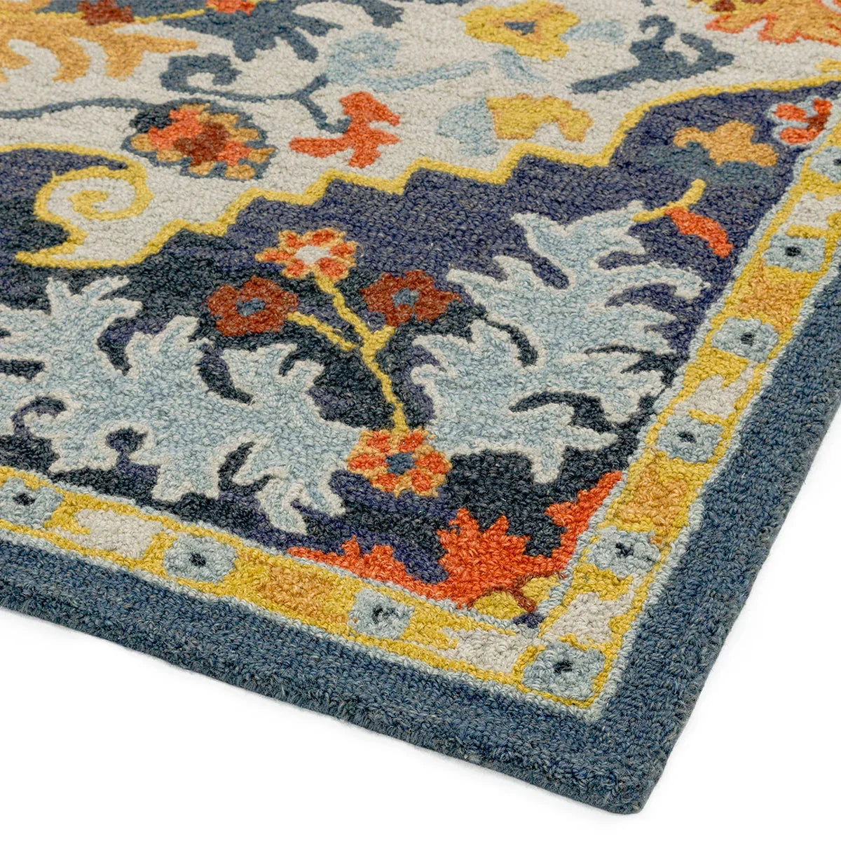 Asiatic Bronte Rug featuring floral arabesque in navy blue, light blue, yellow on cream backdrop, hand-tufted wool