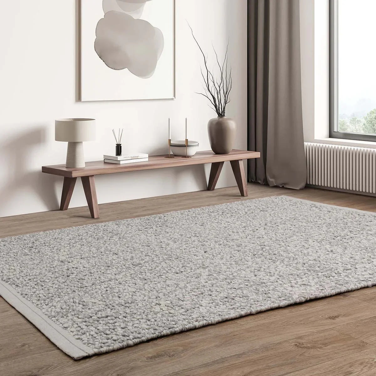Living room with a gray rug, wooden bench, and decorative items.