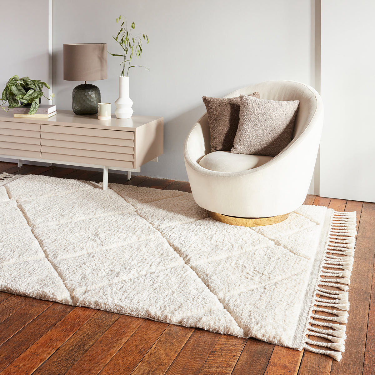 Modern living room with a white rug, chair, and side table.