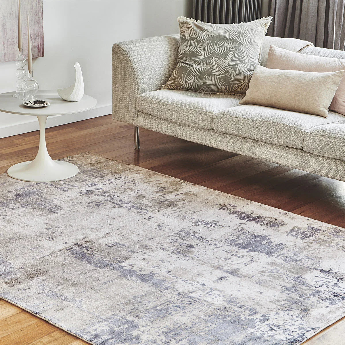 Living room with a patterned rug, sofa, and side table.