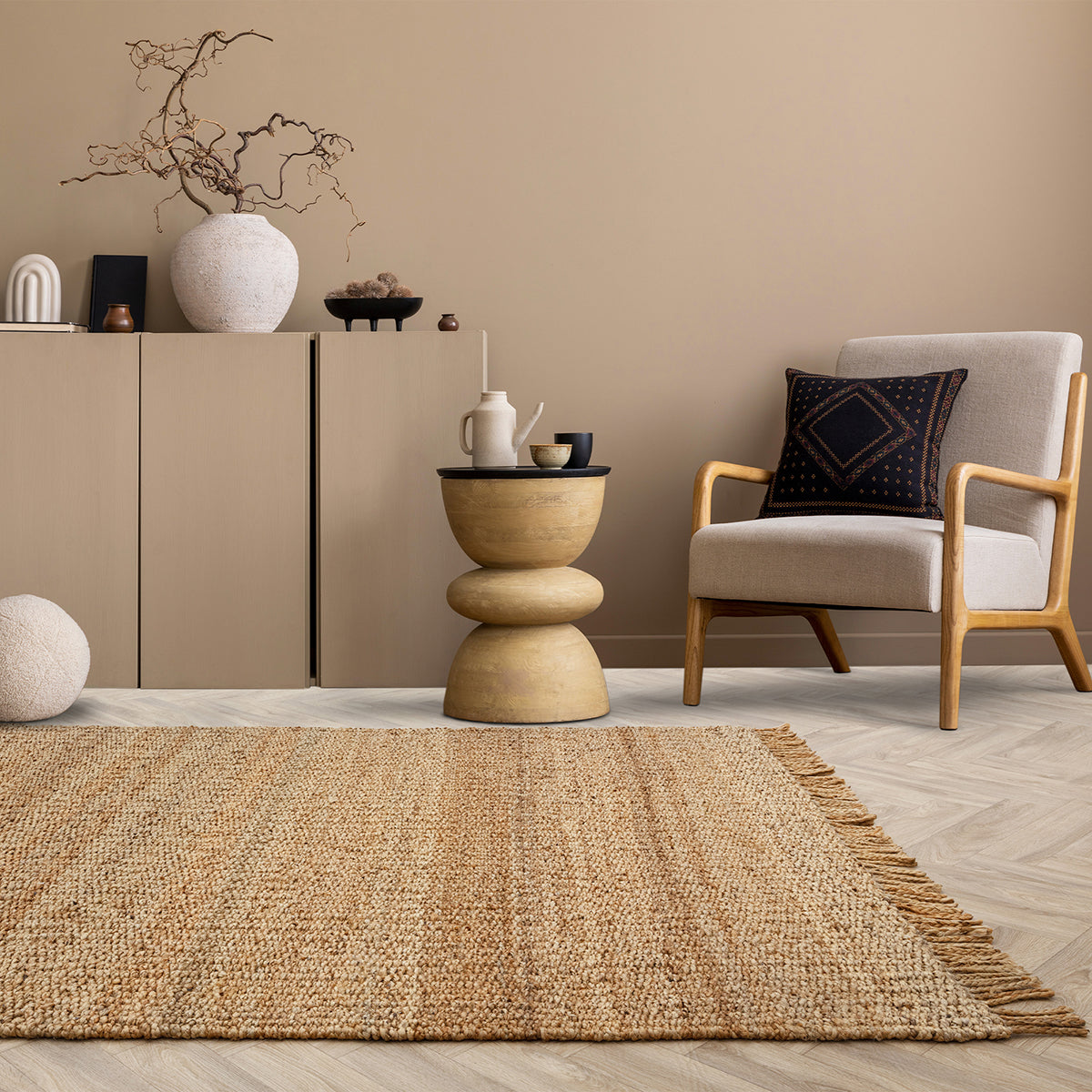 Living room with a beige armchair, wooden side table, and woven rug.