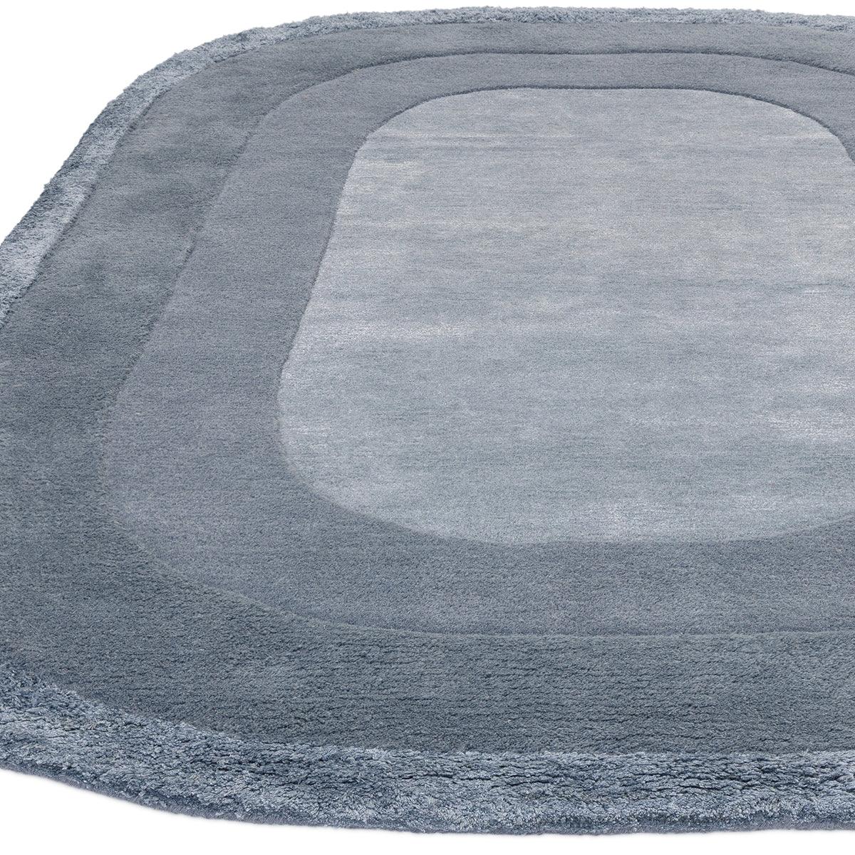 Asiatic Halo Denim Oval Rug featuring halo gradient in denim, navy, steel blue on white background, hand-tufted wool