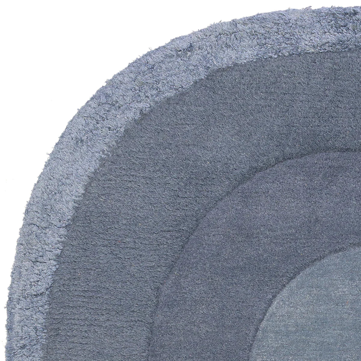 Asiatic Halo Denim Oval Rug featuring concentric halo pattern in denim blue, slate blue and navy on deep navy background, hand-tufted wool