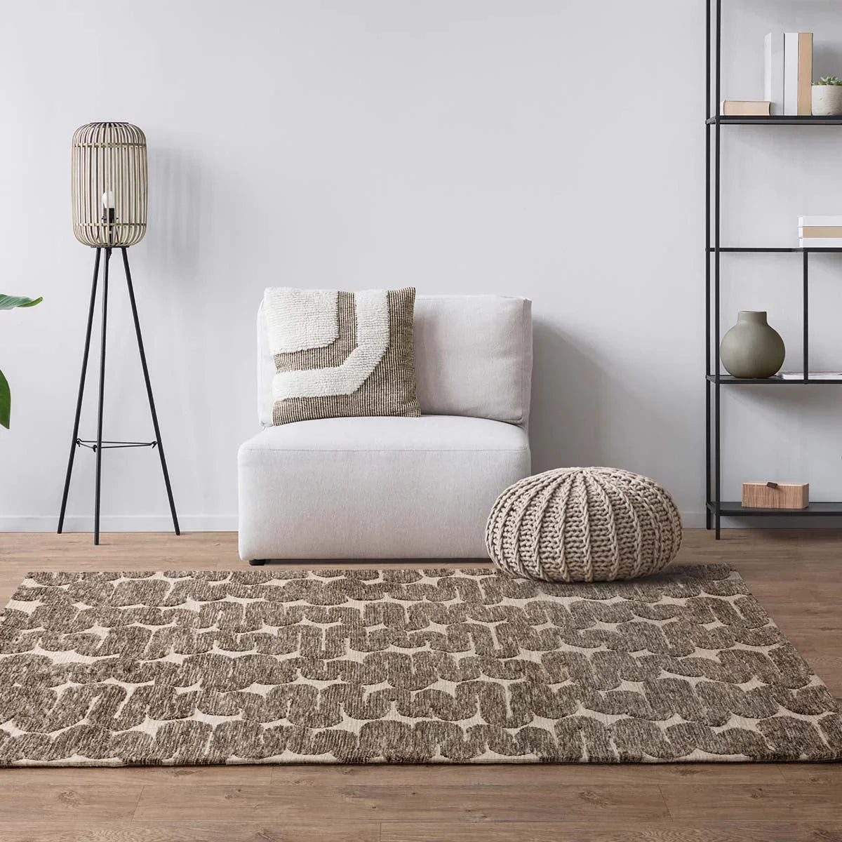 Modern living room with a patterned rug, armchair, and decorative items.