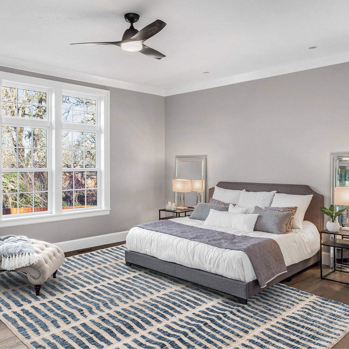 Modern bedroom with a bed, rug, and window view