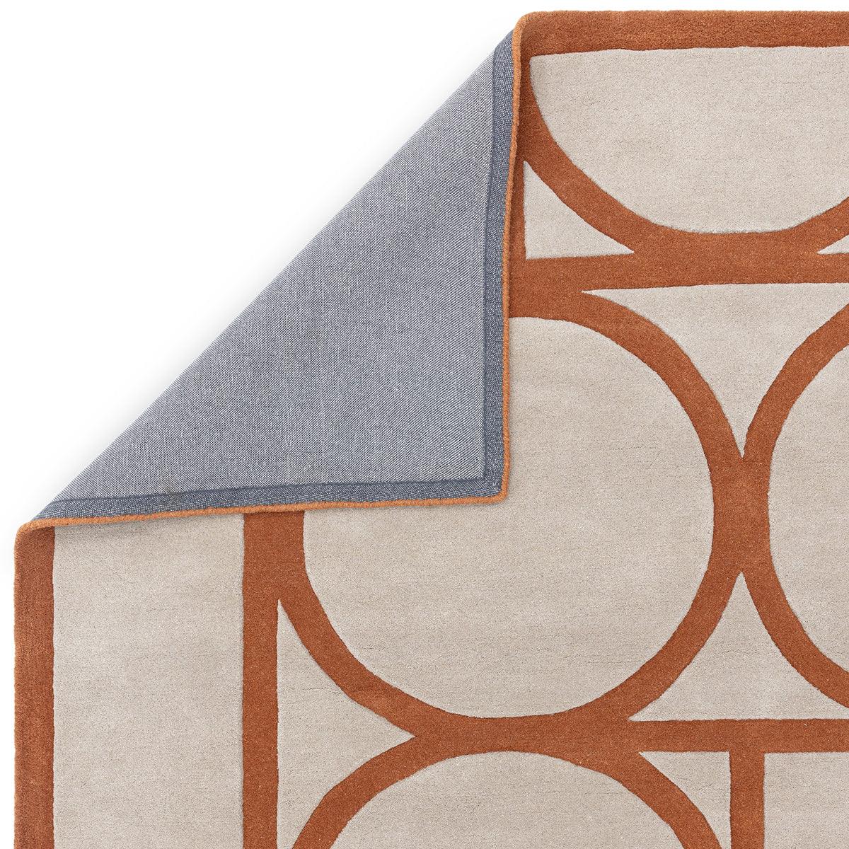 Asiatic Metro Rust Designer Rug featuring circular geometric pattern in rust orange on beige with blue edge, machine-loomed wool