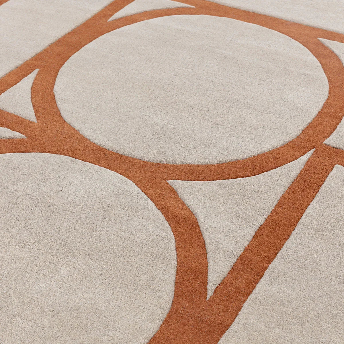 Asiatic Metro Rust Rug featuring abstract circular pattern in rust orange on cream background, hand-tufted wool