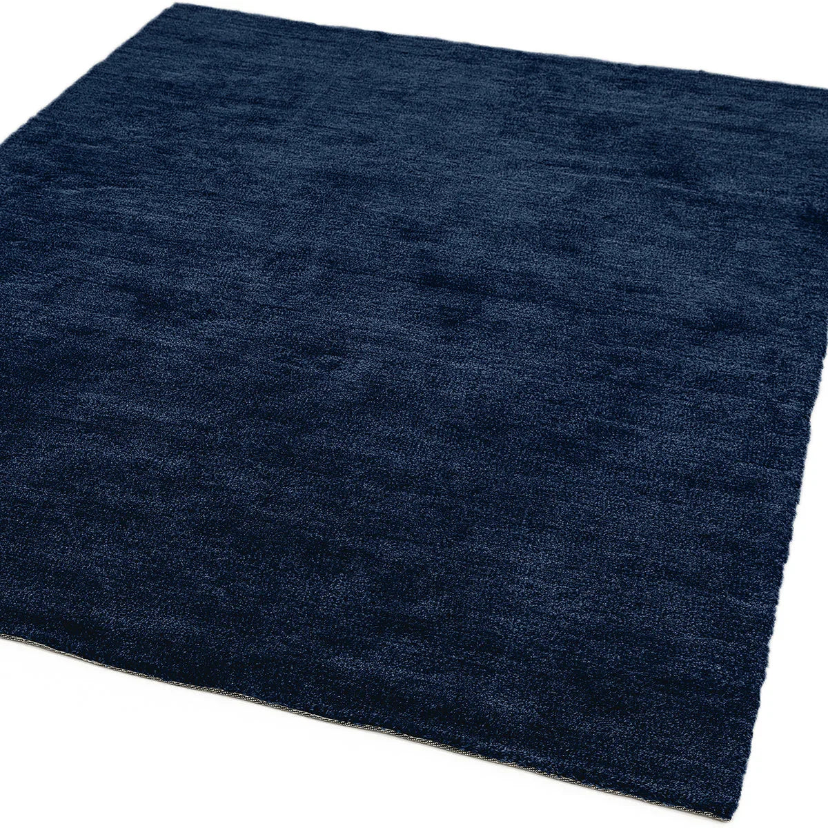 Asiatic Milo Navy Designer Rug featuring solid navy plush texture on white background, hand-tufted wool
