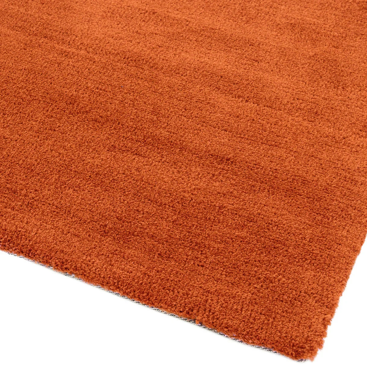 Asiatic Milo Rust Designer Rug featuring solid rust-orange shag in rust orange on white background, machine-made rug