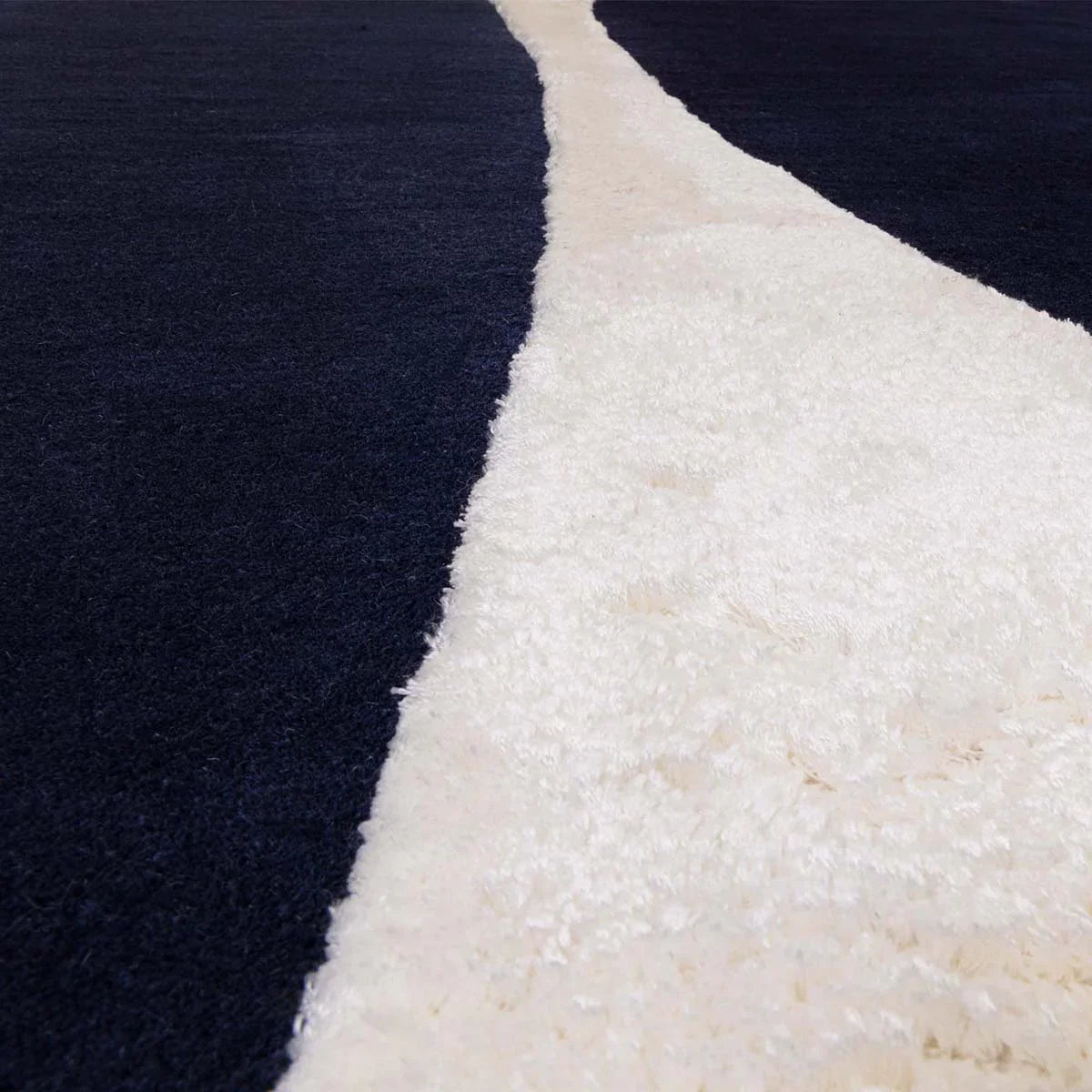 Asiatic Matrix Signature Indigo Designer Rug featuring abstract navy indigo and ivory blocks on cream background, hand-tufted wool