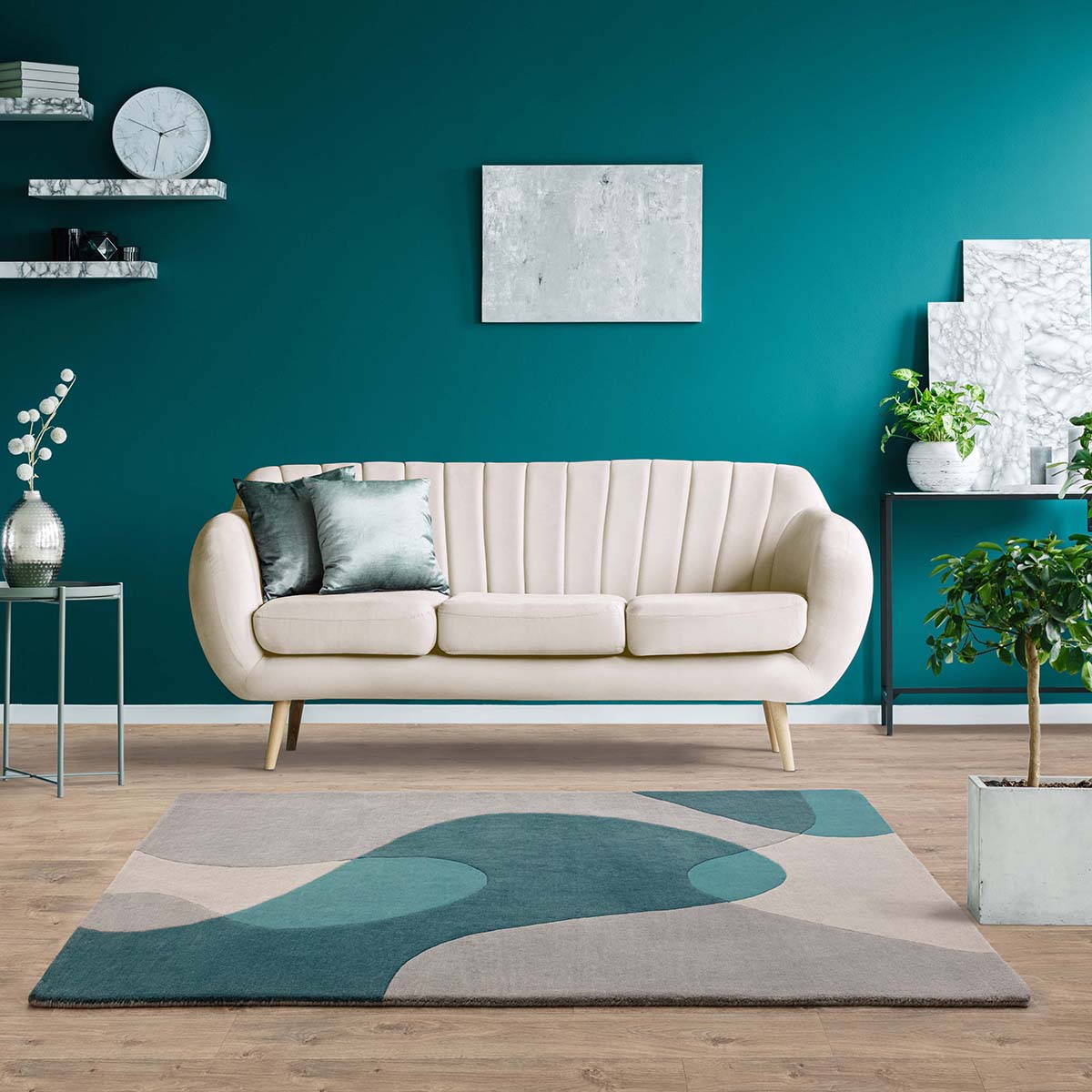 Modern living room with a beige sofa, teal rug, and teal walls.