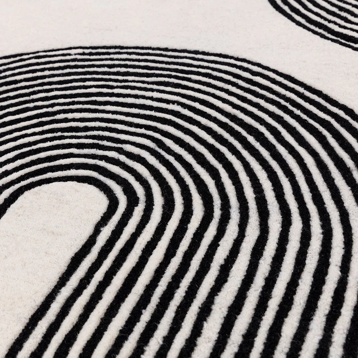 Asiatic Matrix Arches Black Designer Rug featuring concentric arch pattern in black and white on ivory background, hand-tufted wool