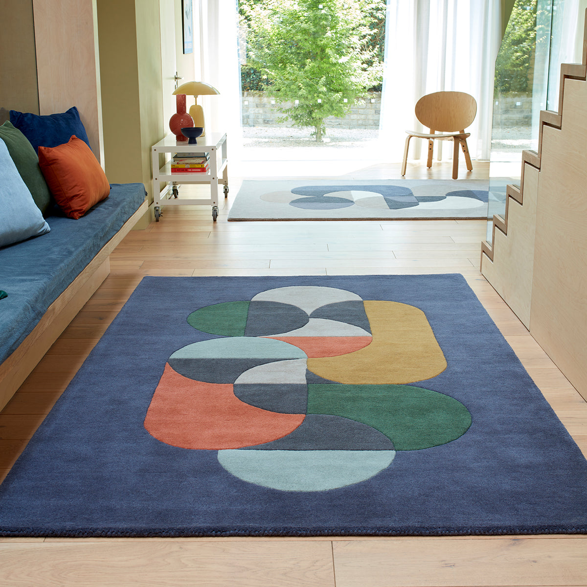 Colorful abstract rug on a wooden floor with a modern interior setting.