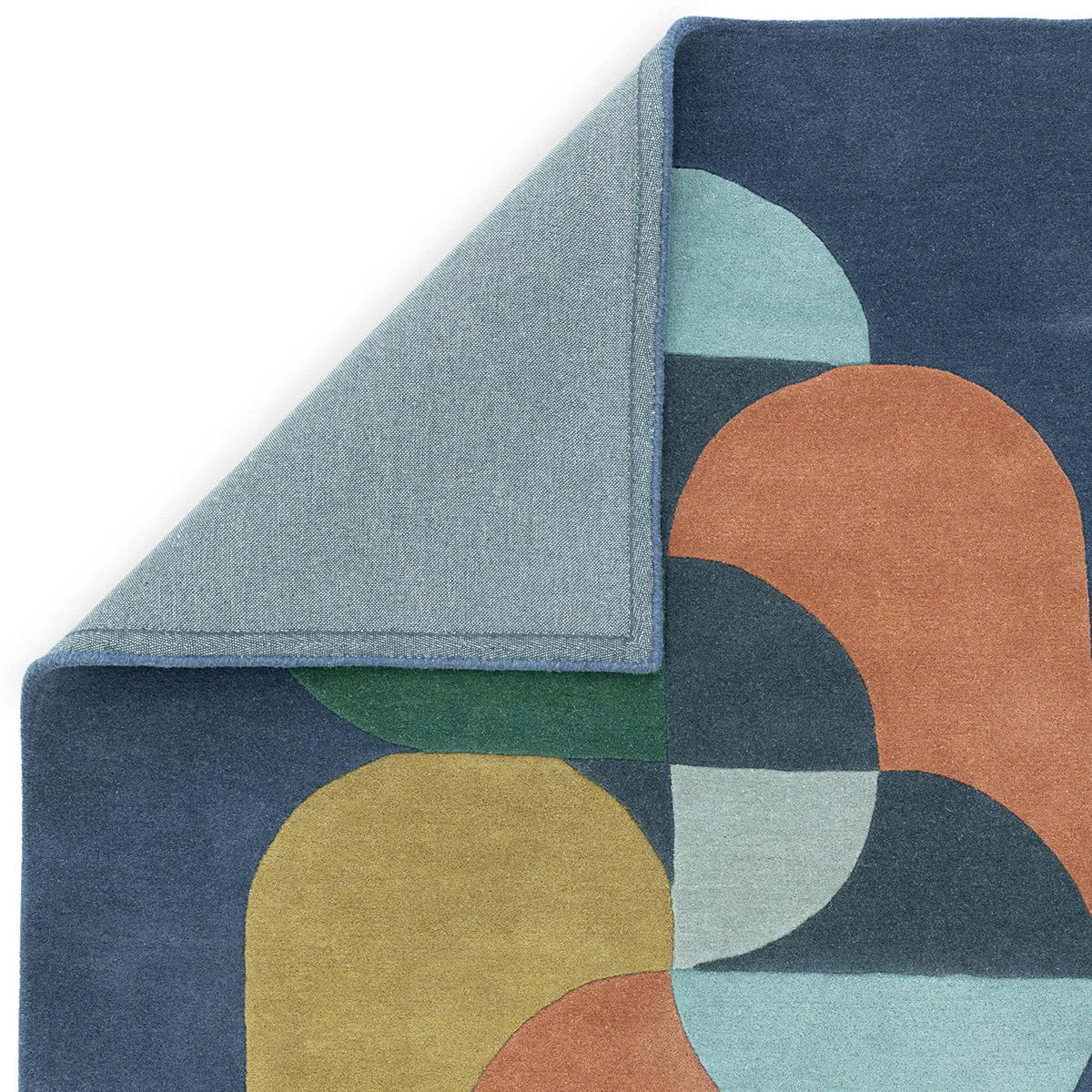 Asiatic Matrix 91 rug featuring geometric arc pattern in navy, teal, ochre and sage green on deep navy ground, hand-tufted wool
