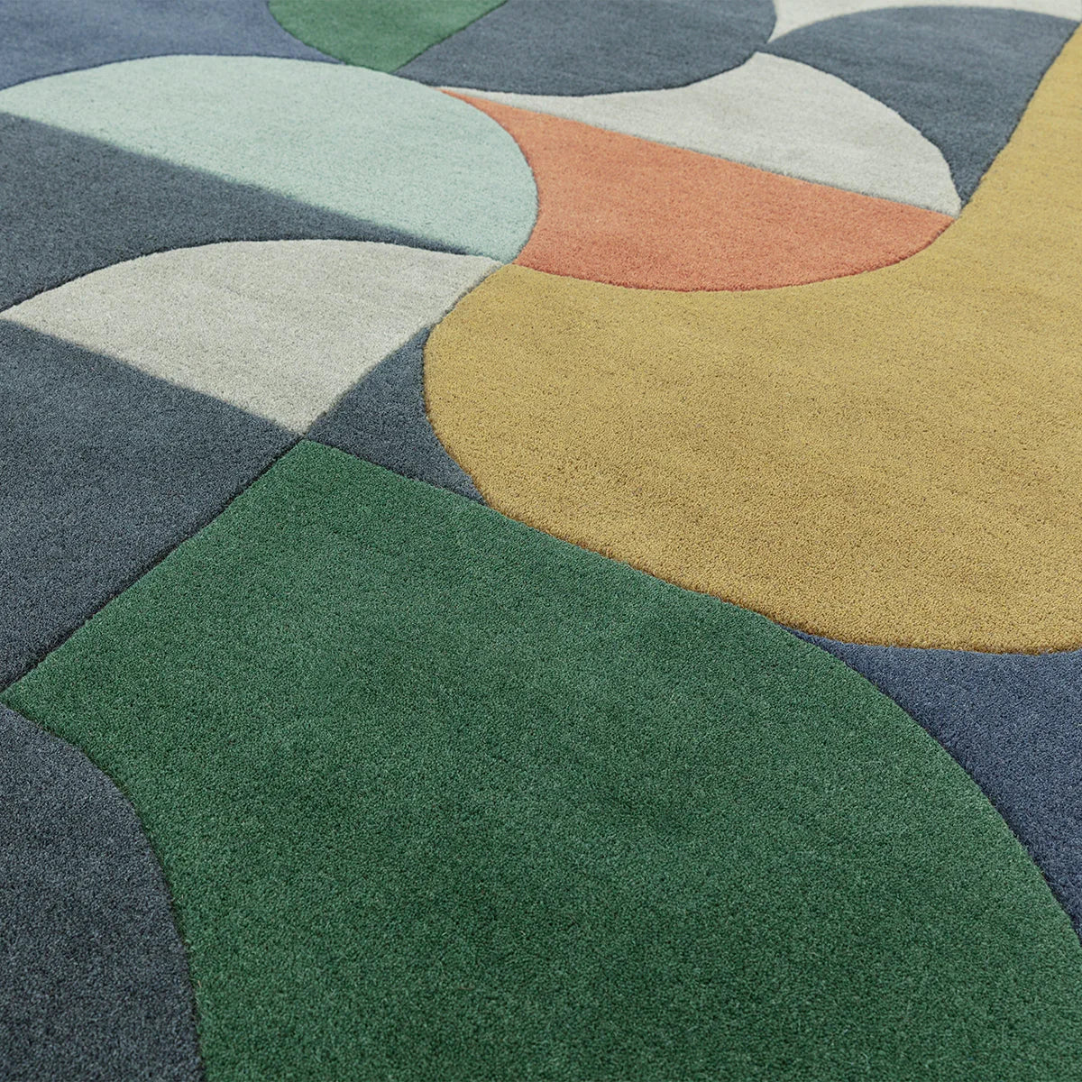 Asiatic Matrix 91 Statement Navy Designer Rug featuring abstract curved patchwork in navy, emerald green, mustard, cream on deep navy background, hand-tufted wool