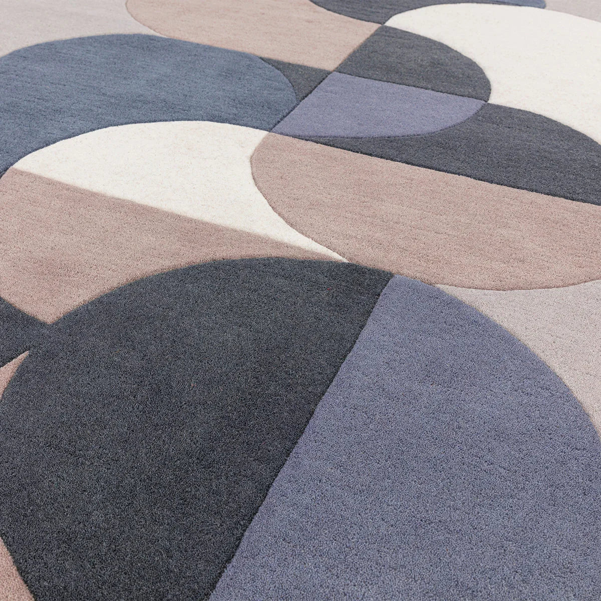 Asiatic Matrix 92 rug featuring abstract curved blocks in charcoal, slate blue, dusty pink on light grey background, machine-woven wool
