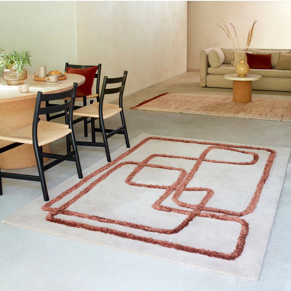 Living room with a patterned rug, dining table, and sofa.