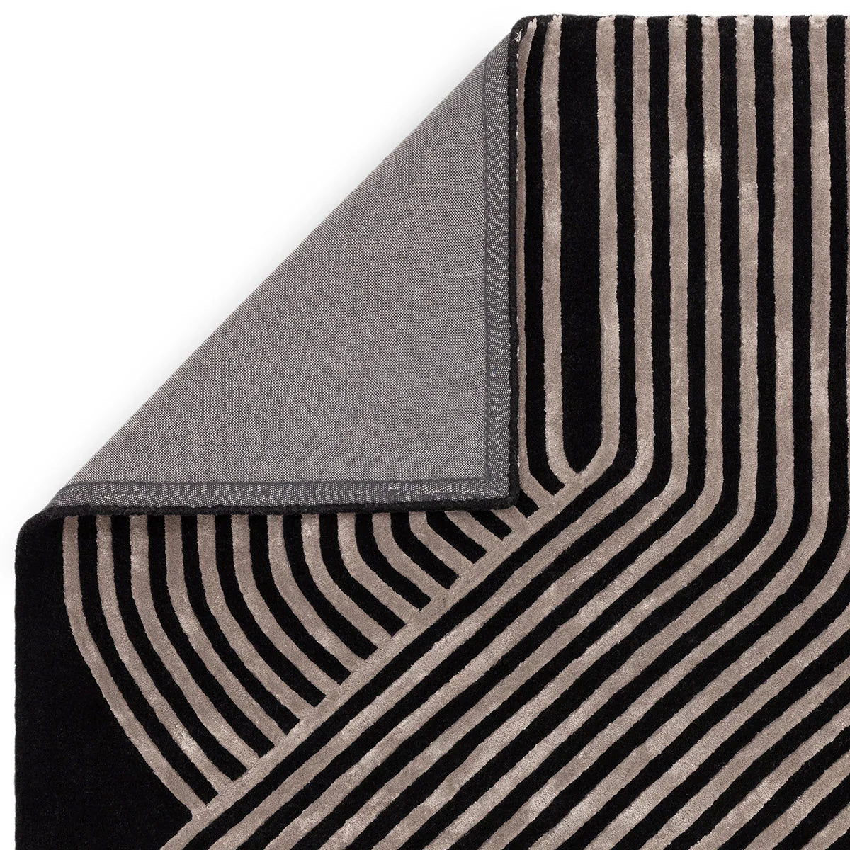 Asiatic Matrix Solstice Rug featuring striped geometric pattern in gunmetal gray and black on dark backdrop, machine-woven wool