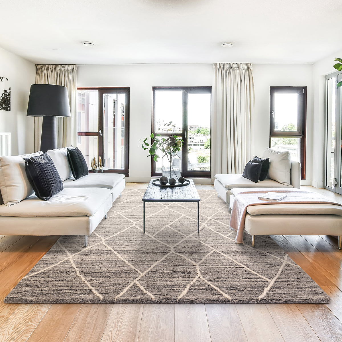 Modern living room with a patterned rug, white sofa, and coffee table.