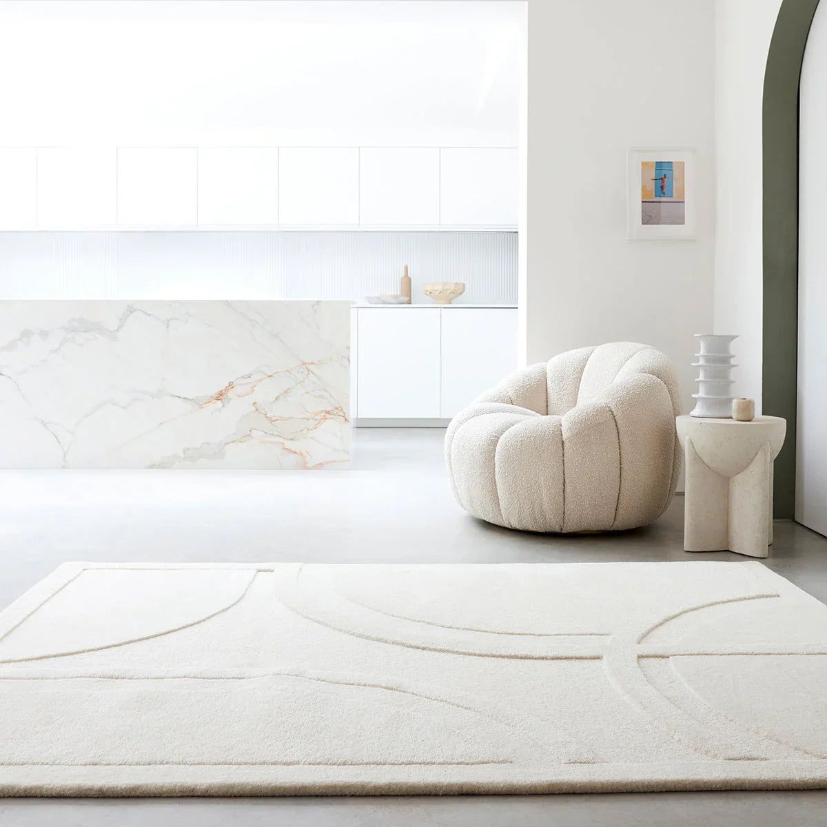 Modern living room with a white rug, chair, and side table.