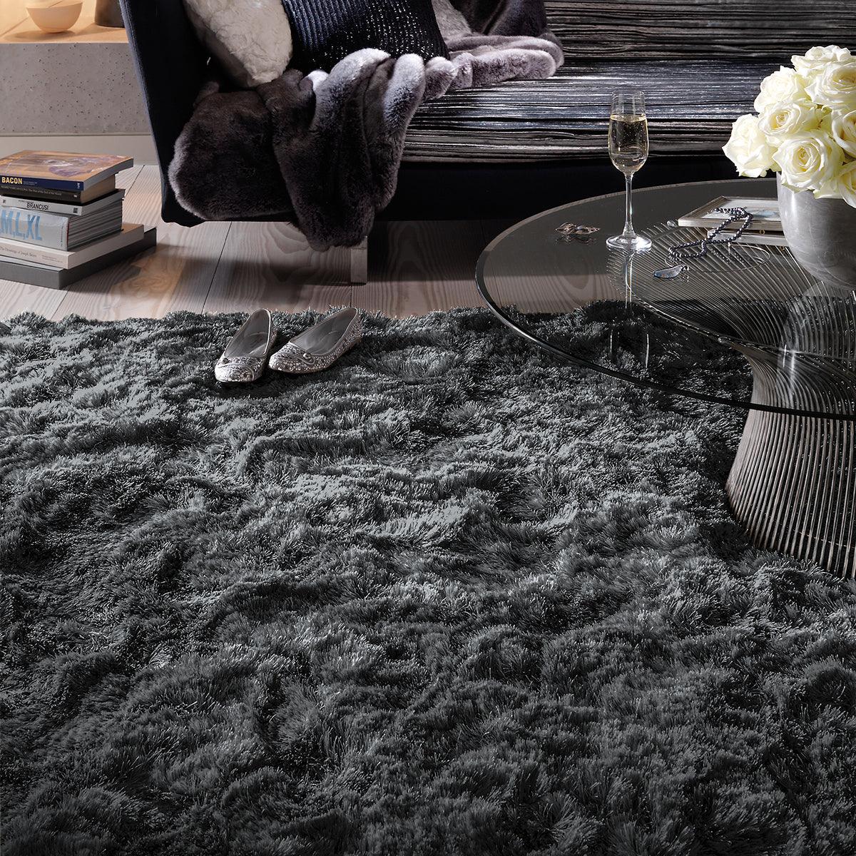 Living room with a dark gray textured rug, a glass table, and a sofa.