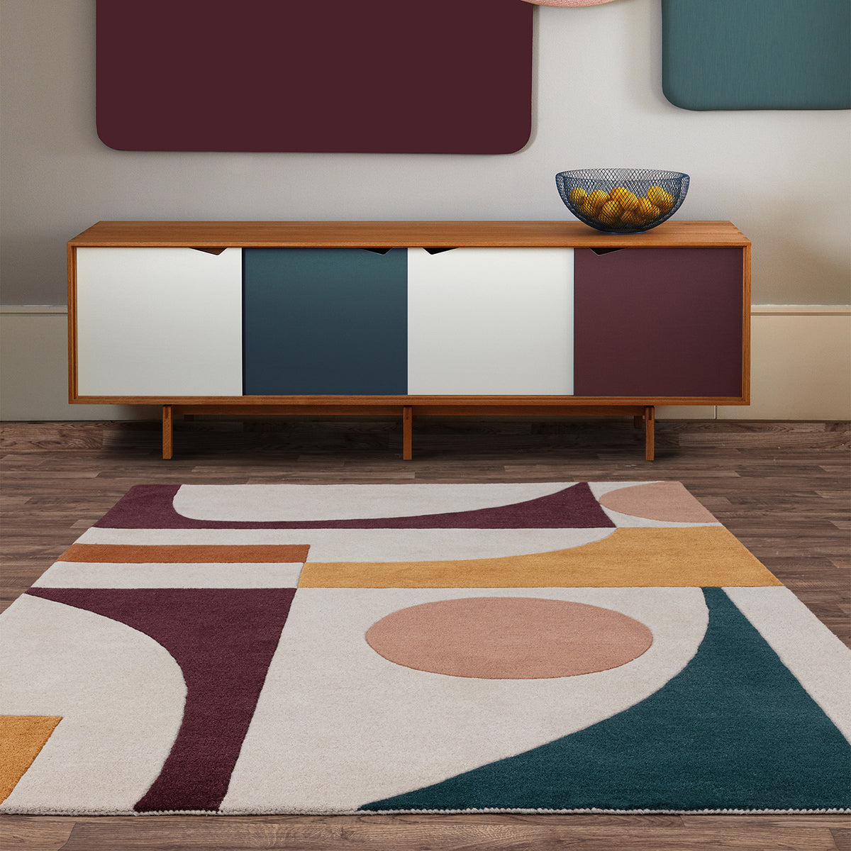 Modern room interior with a wooden sideboard and geometric-patterned rug.