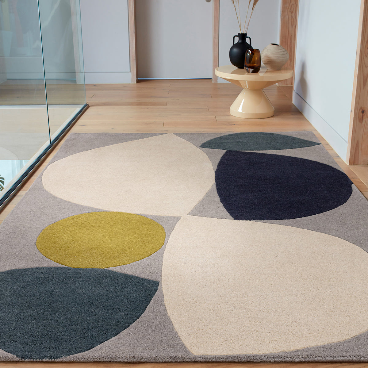 Colorful geometric rug on a wooden floor with a modern interior setting.