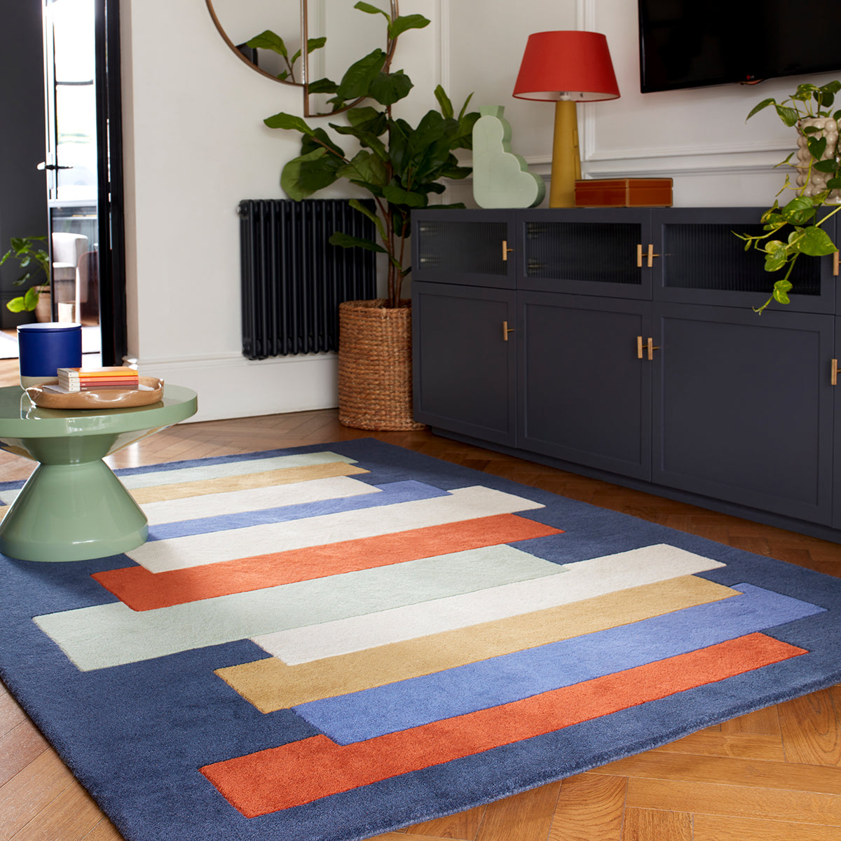 Colorful striped rug on a wooden floor with a modern living room setting.