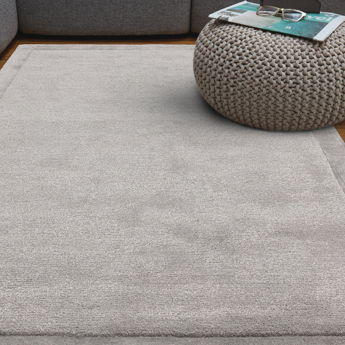 Gray rug with a textured ottoman in a living room setting