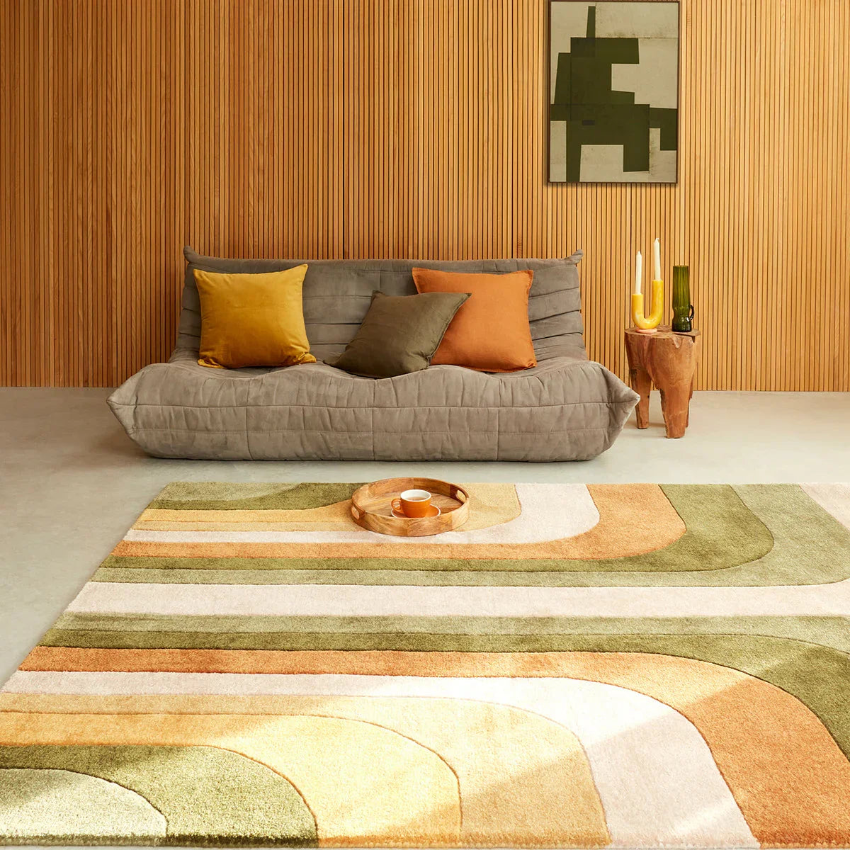 Living room with a gray sofa, colorful rug, and abstract painting on the wall.