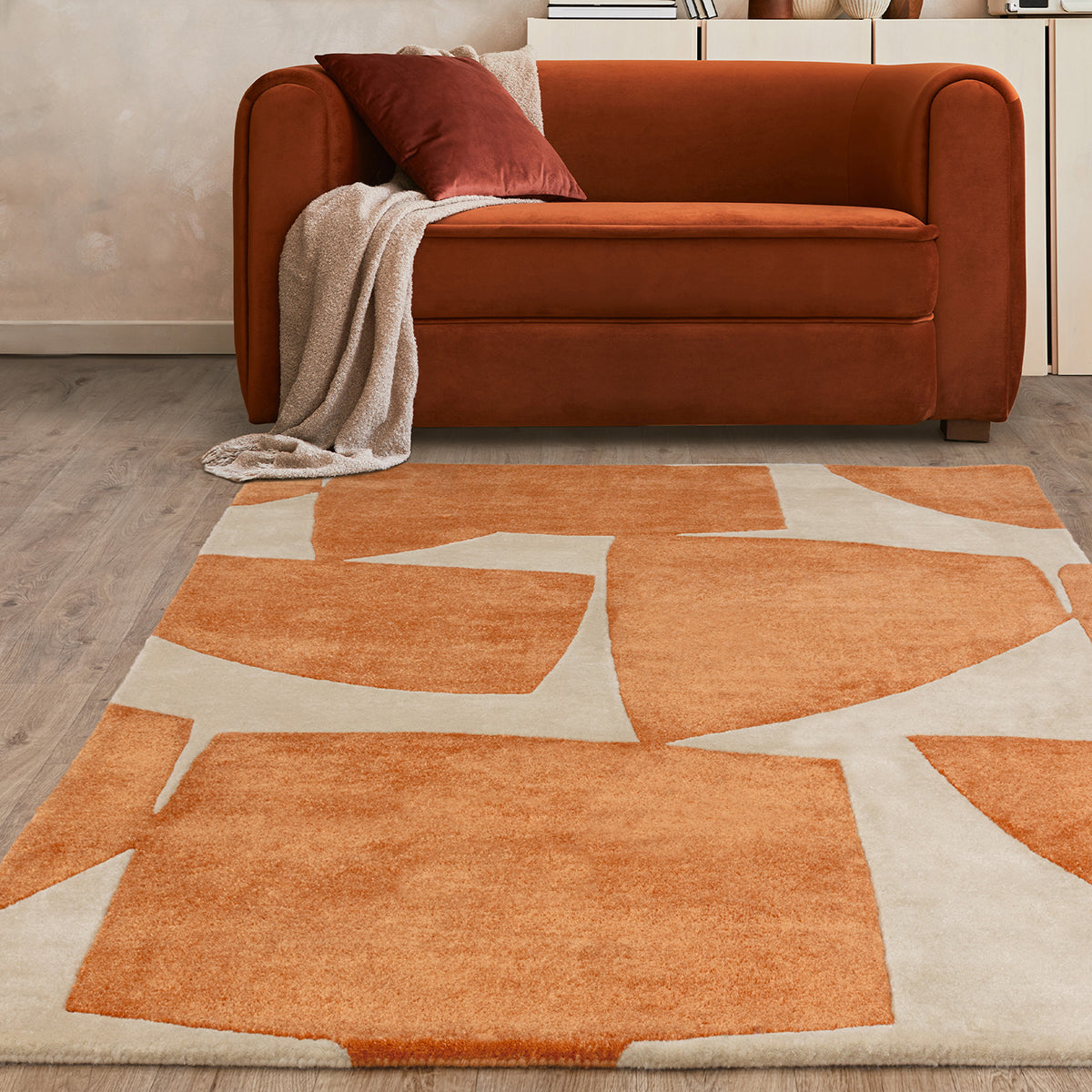 Orange sofa with a patterned rug in a living room setting