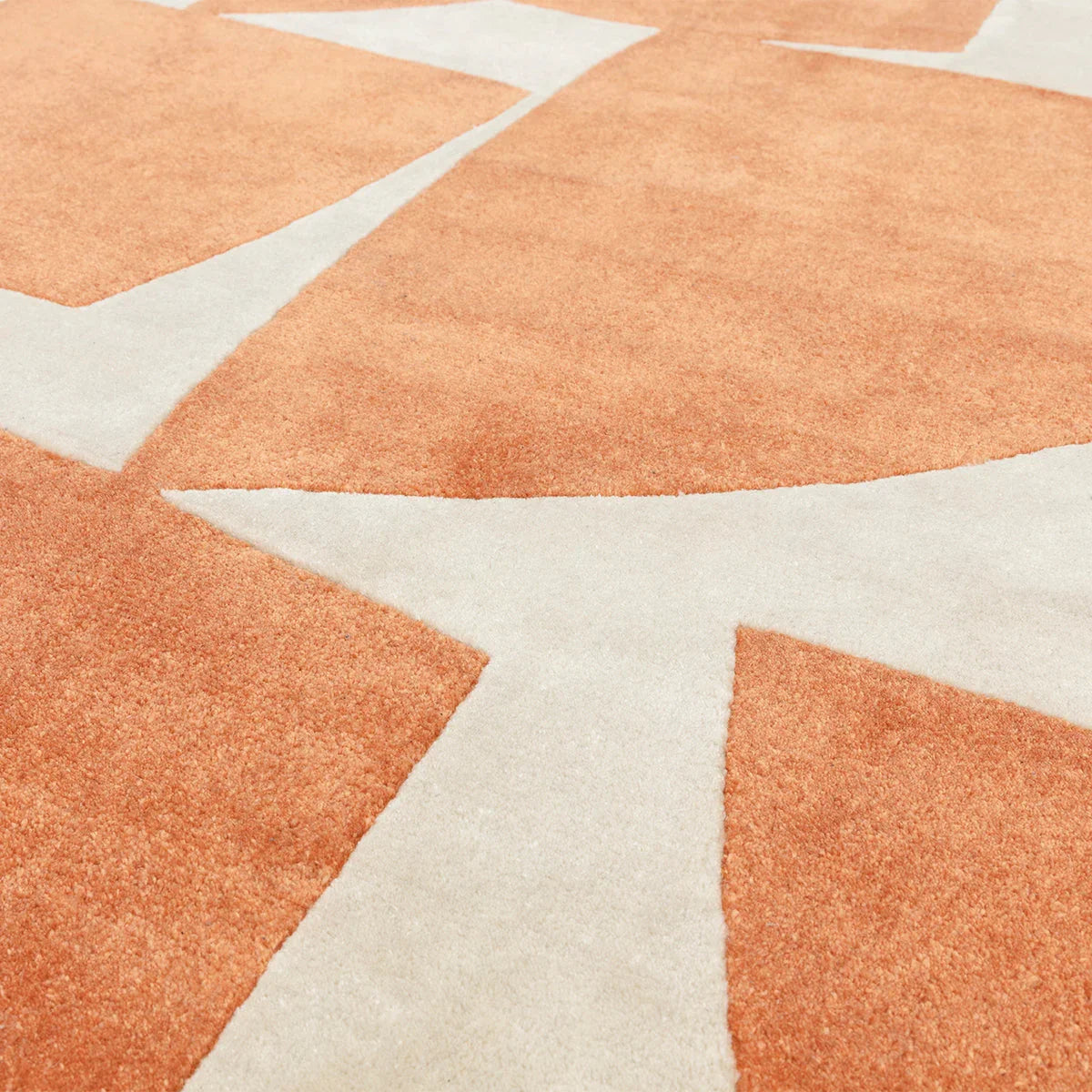 Asiatic Romy Kite Orange rug featuring bold geometric kite/star pattern in burnt orange and cream on ivory background, hand-tufted wool