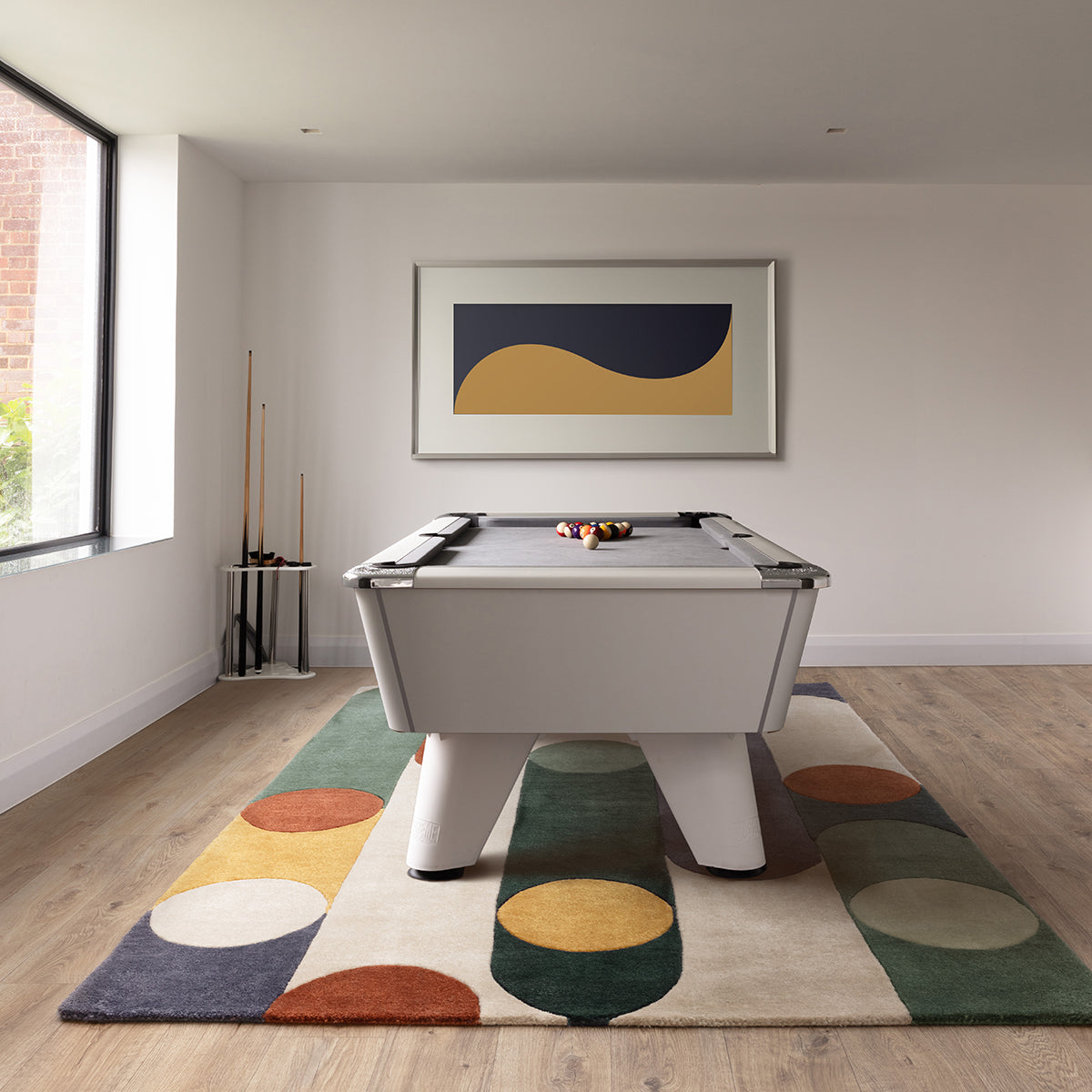 Pool table in a room with a colorful rug and abstract art on the wall