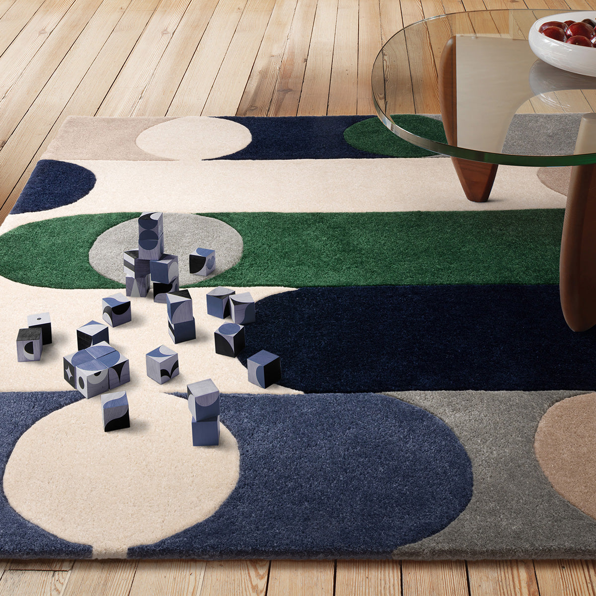 Colorful abstract rug on a wooden floor with geometric shapes.