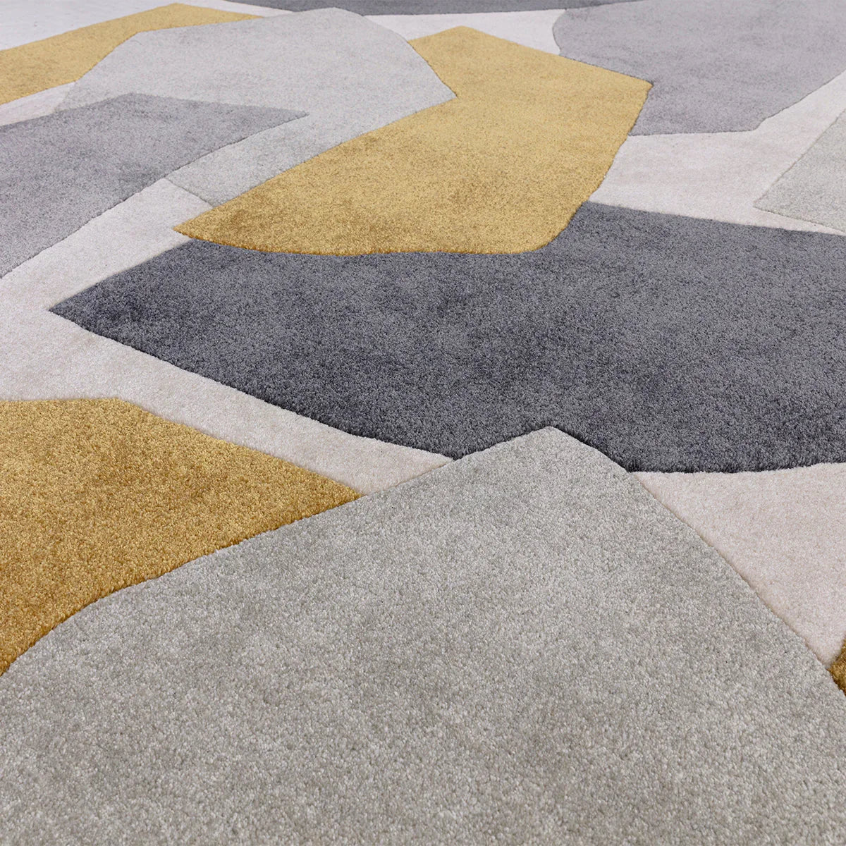 Asiatic Romy 10 Element Ochre rug featuring geometric patchwork in ochre, charcoal, grey and ivory on light beige background, machine-woven wool