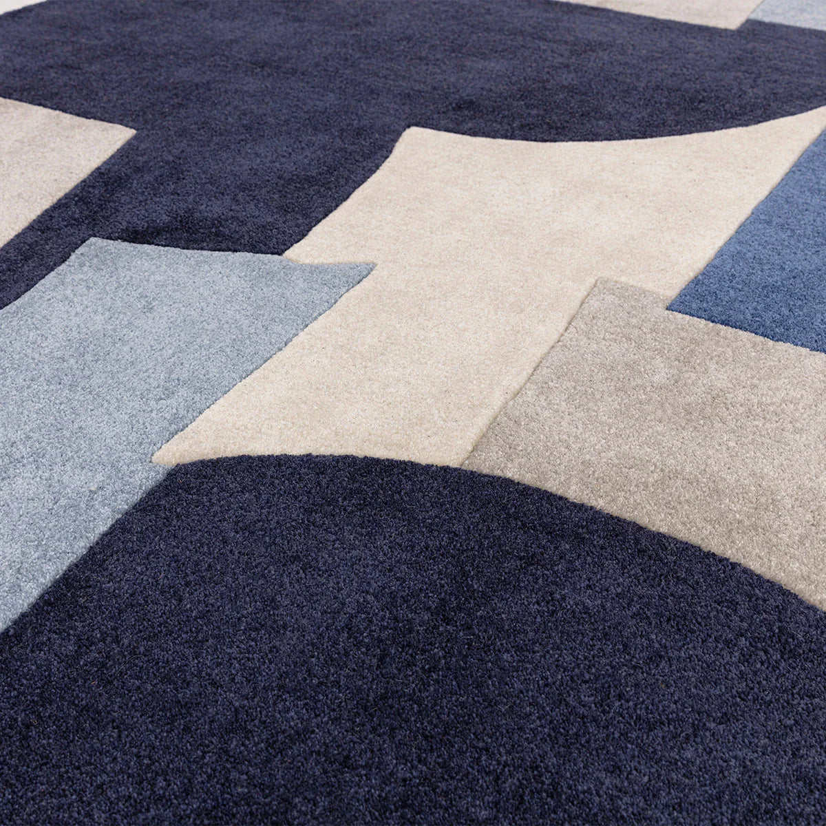 Asiatic Romy Element Blue Rug featuring geometric patchwork in navy, cream, pale blue on cream background, hand-tufted wool