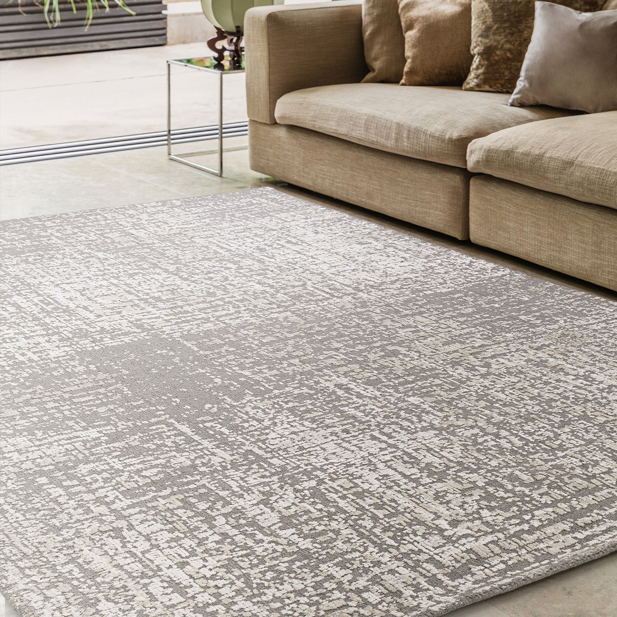 Gray patterned rug in a living room with a beige sofa.