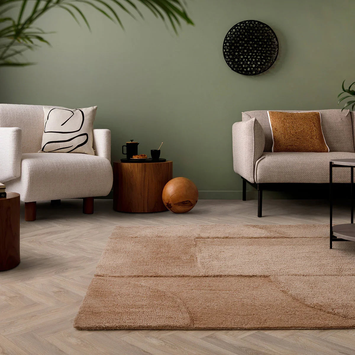 Modern living room with beige sofa, armchair, and coffee table on a wooden floor.