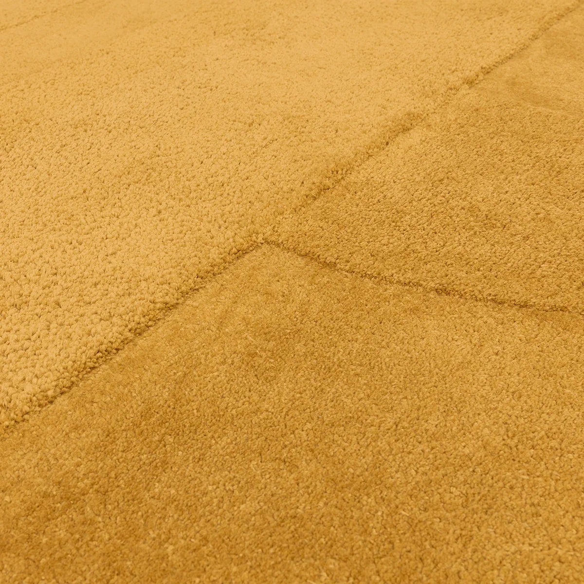 Asiatic Tova Ochre Designer Rug featuring geometric seam lines in ochre on a warm golden field, hand-tufted wool