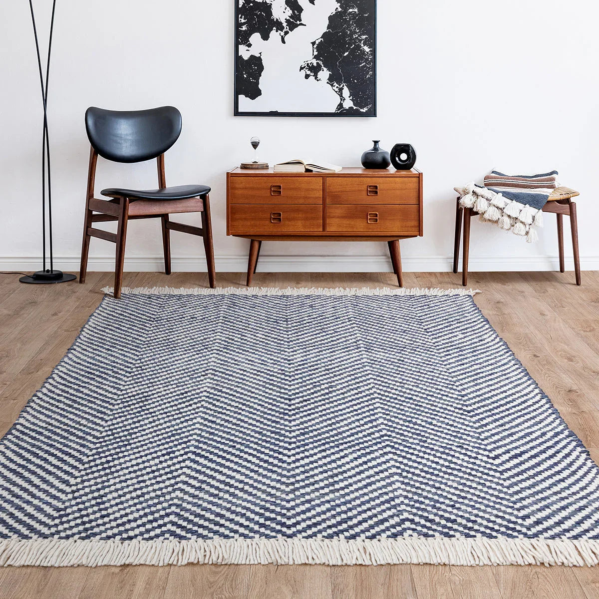 Living room with a blue and white patterned rug, wooden chair, and sideboard.