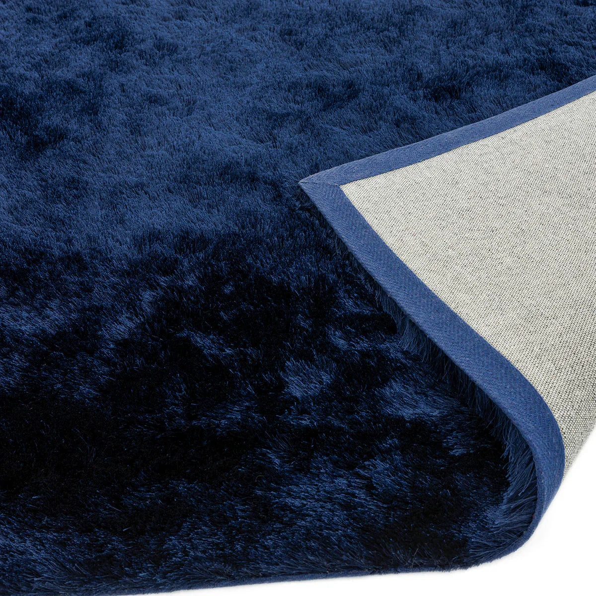 Asiatic Whisper Navy Blue Designer Rug featuring solid shag in navy blue on light beige backing, hand-tufted wool